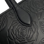 Close-up of tone-on-tone embossed rose florals on sable black vegan leather